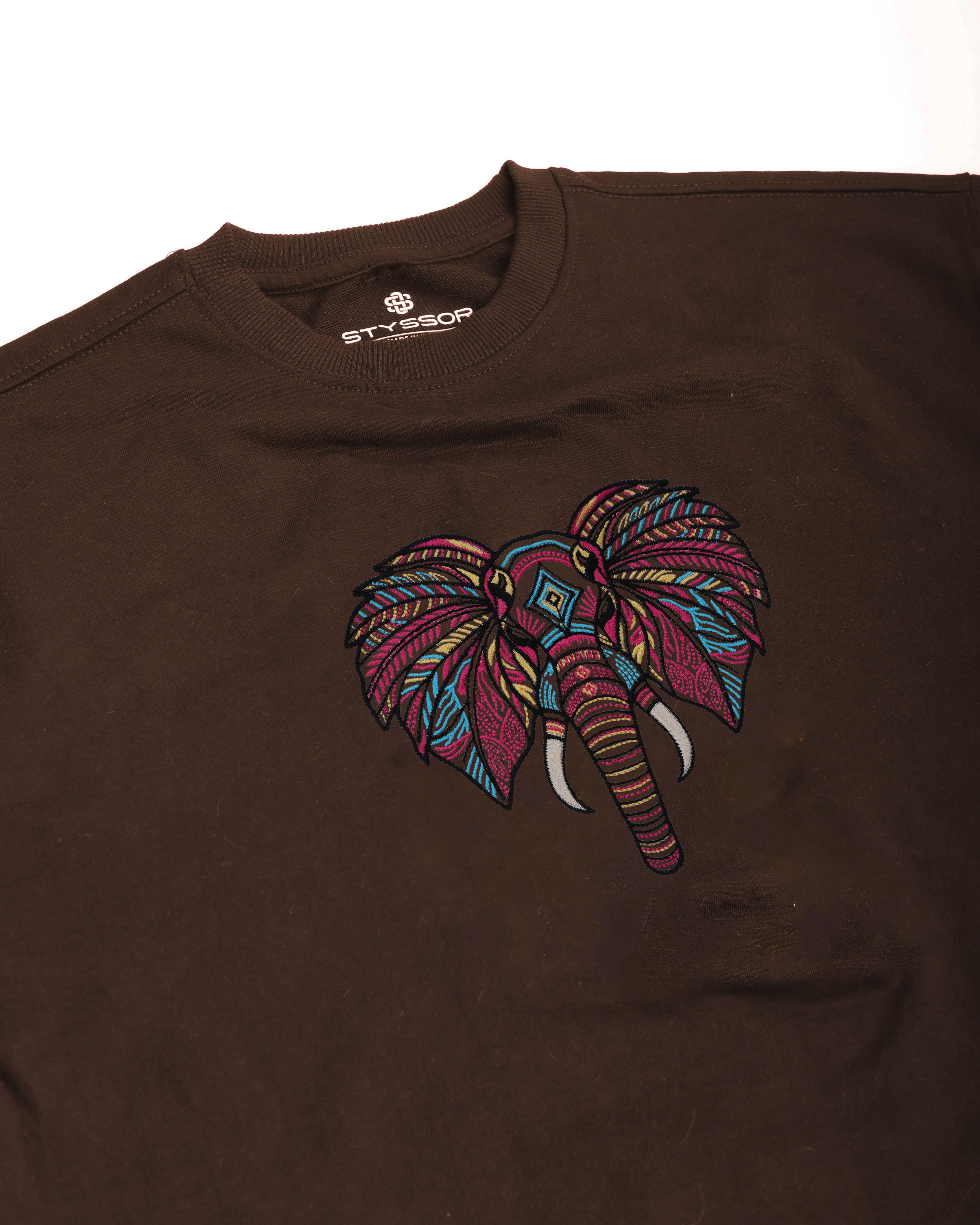 Brown t-shirt with a colorful elephant design on a white background