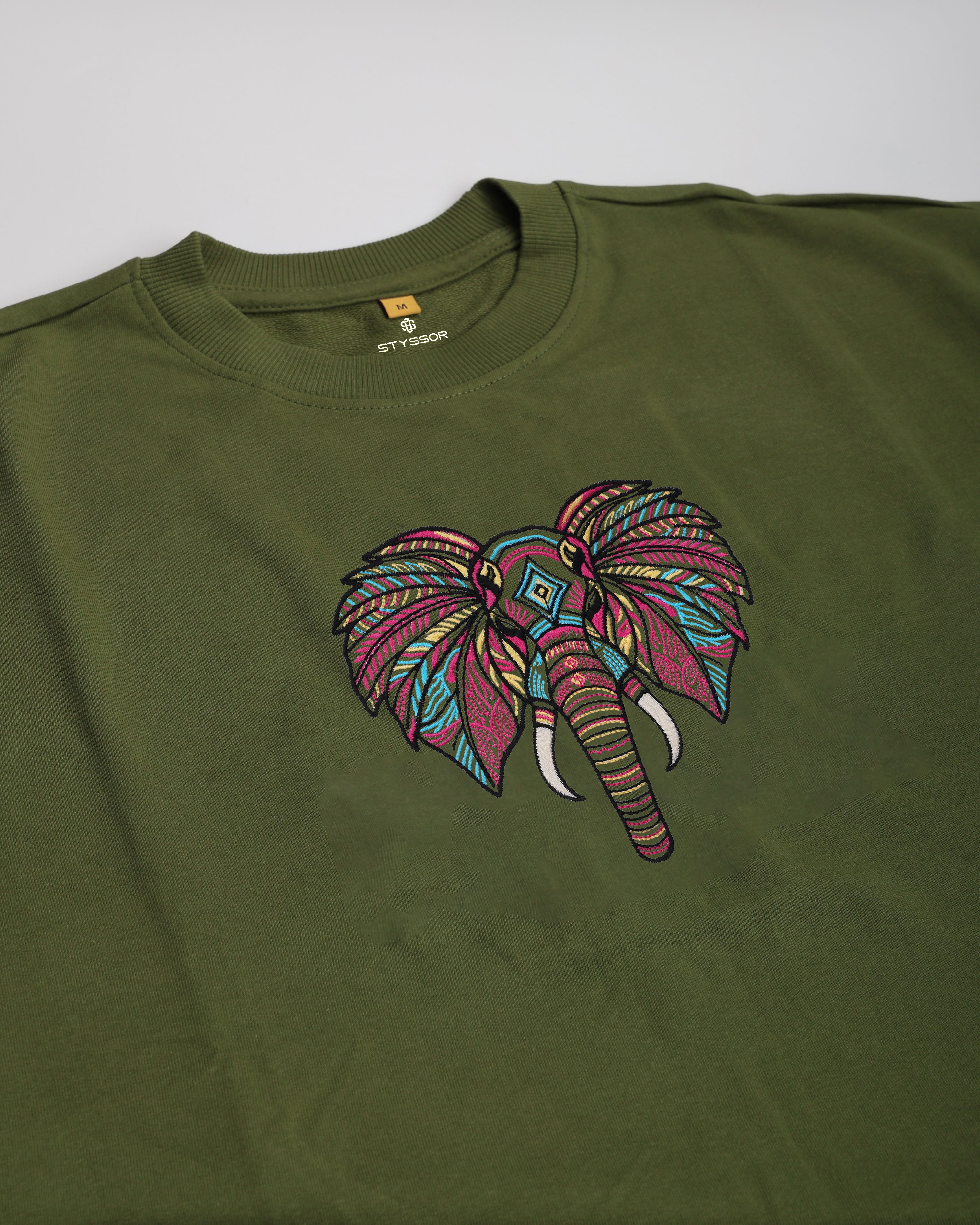Green t-shirt with a colorful elephant design on a white background