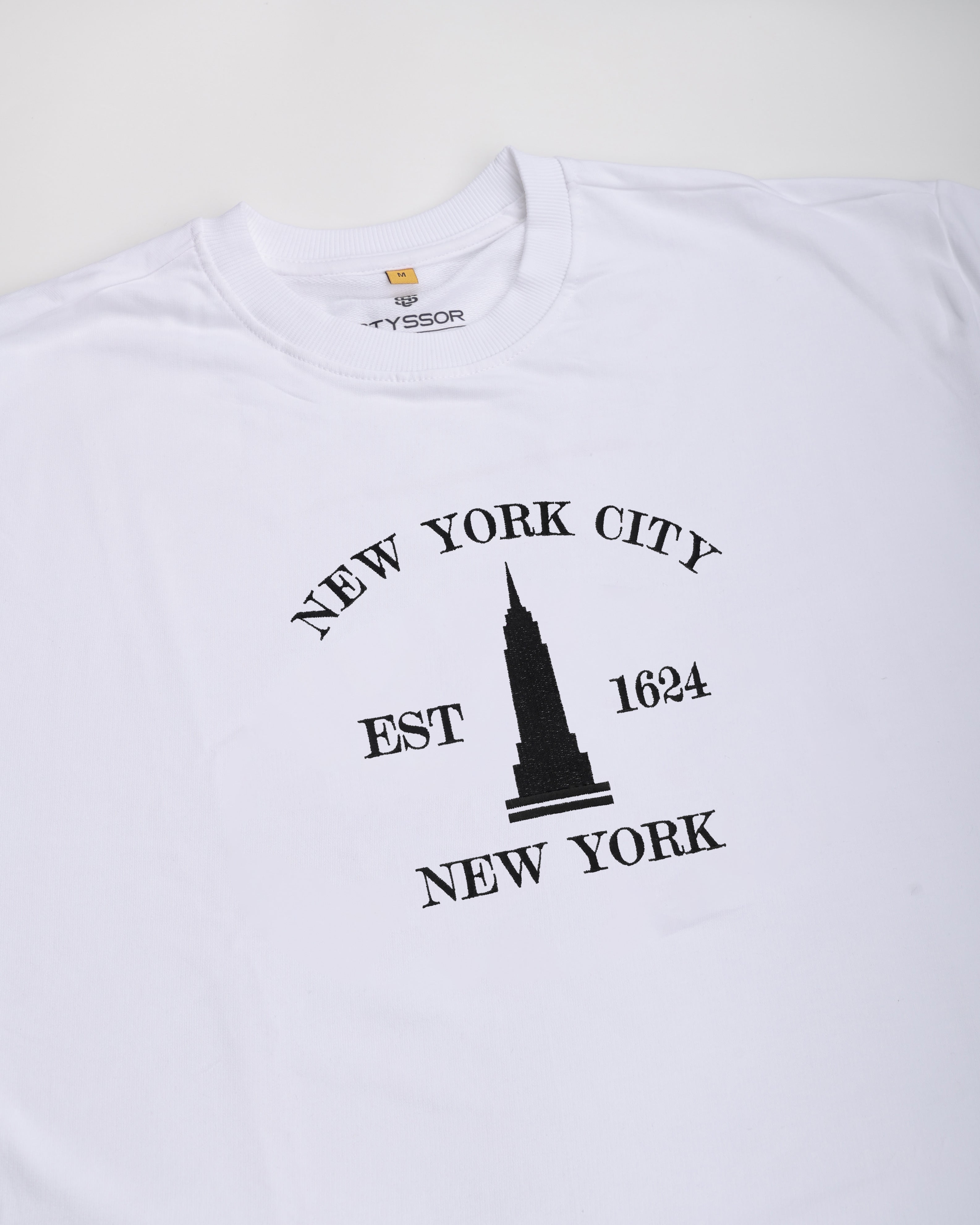 White t-shirt with black 'New York City' and Empire State Building graphic on a white background