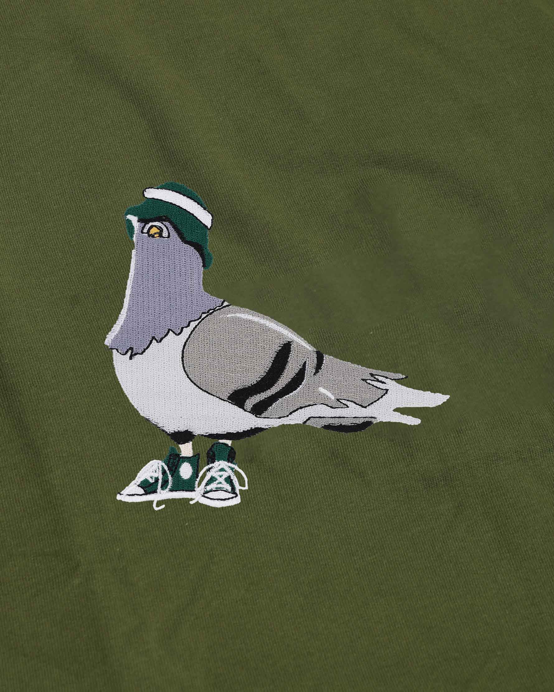 Embroidered pigeon with a hat and shoes on a green background
