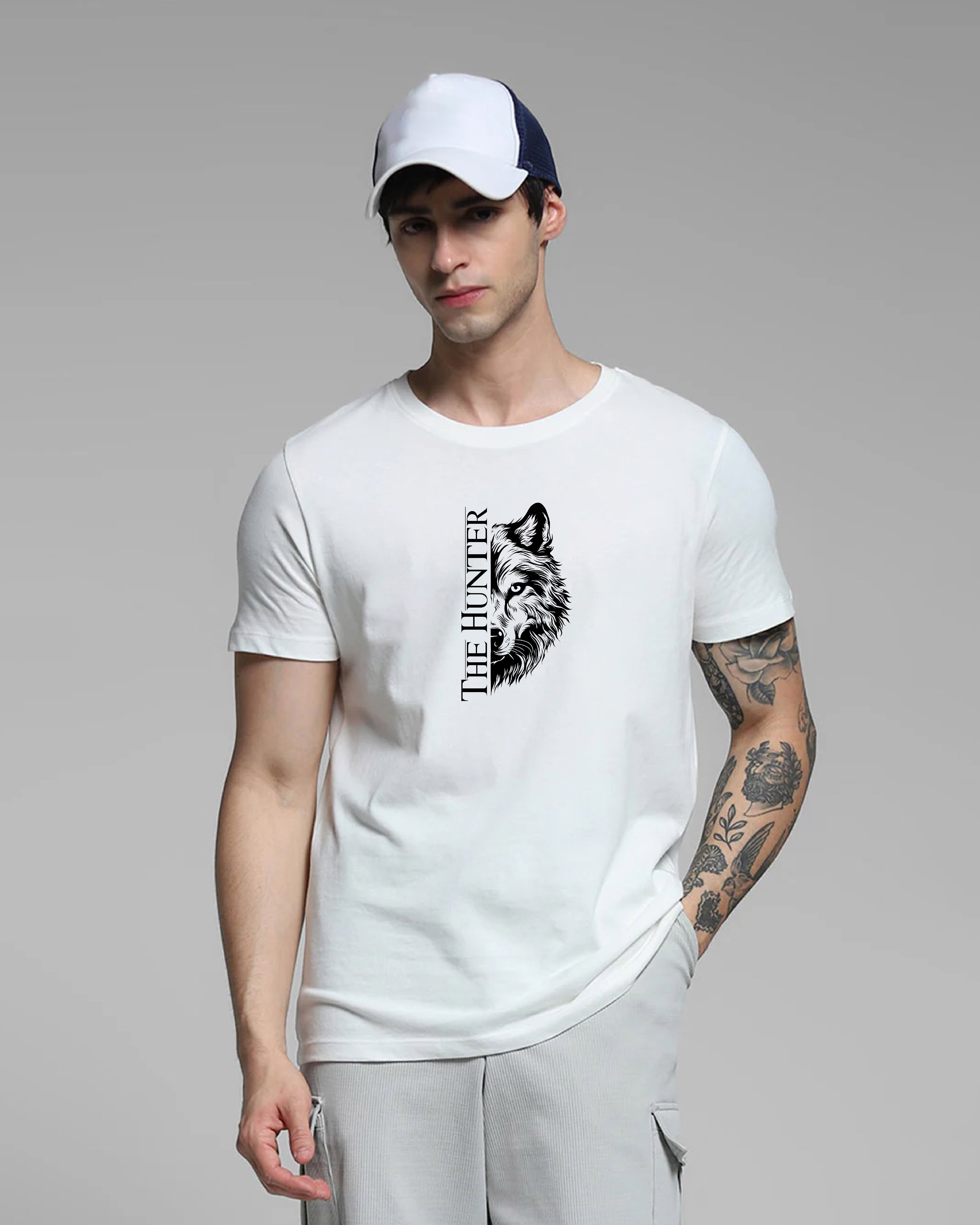 Man wearing a white t-shirt with a wolf graphic and 'The Hunter' text, standing against a gray background.