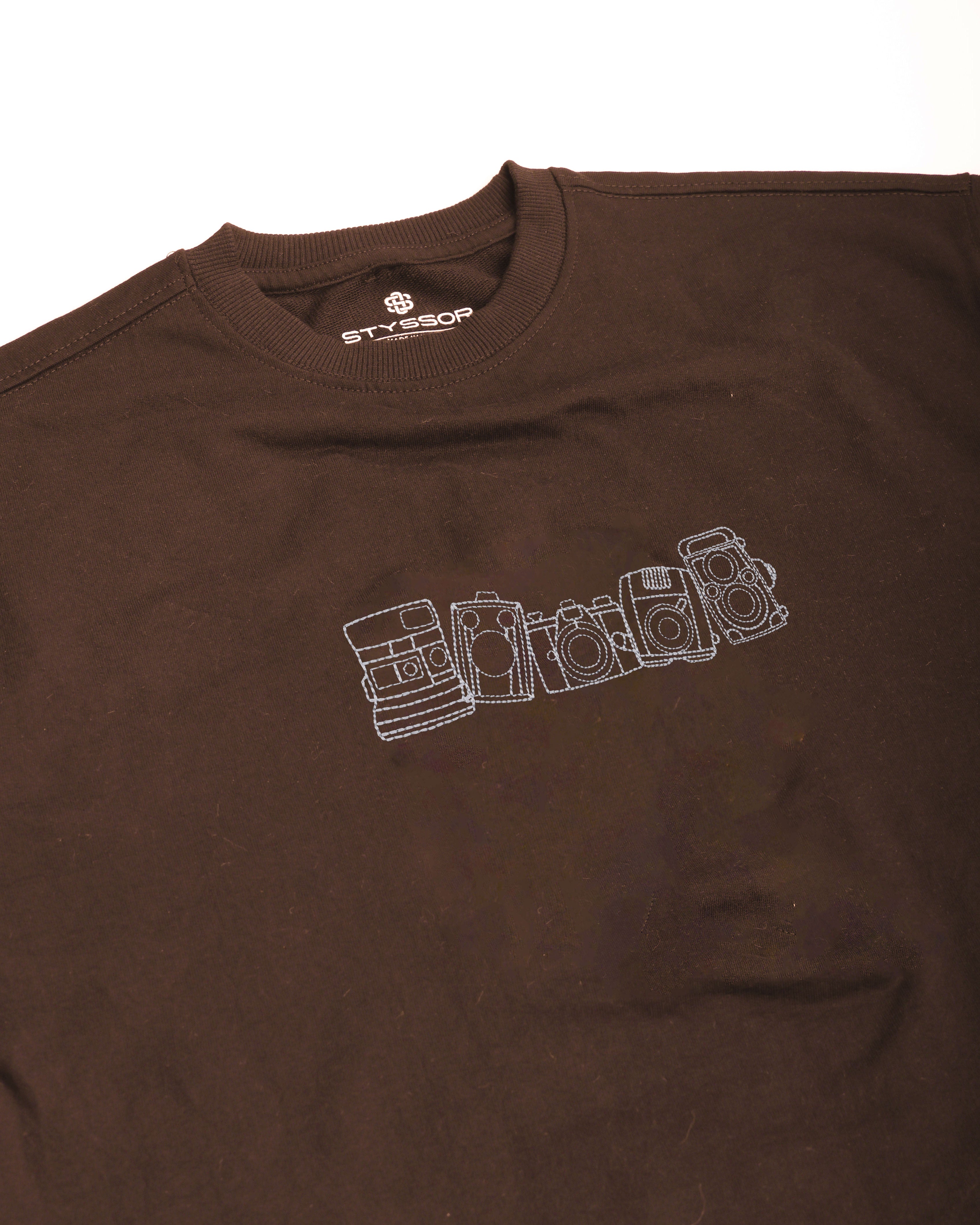 Brown t-shirt with white graphic design on a white background