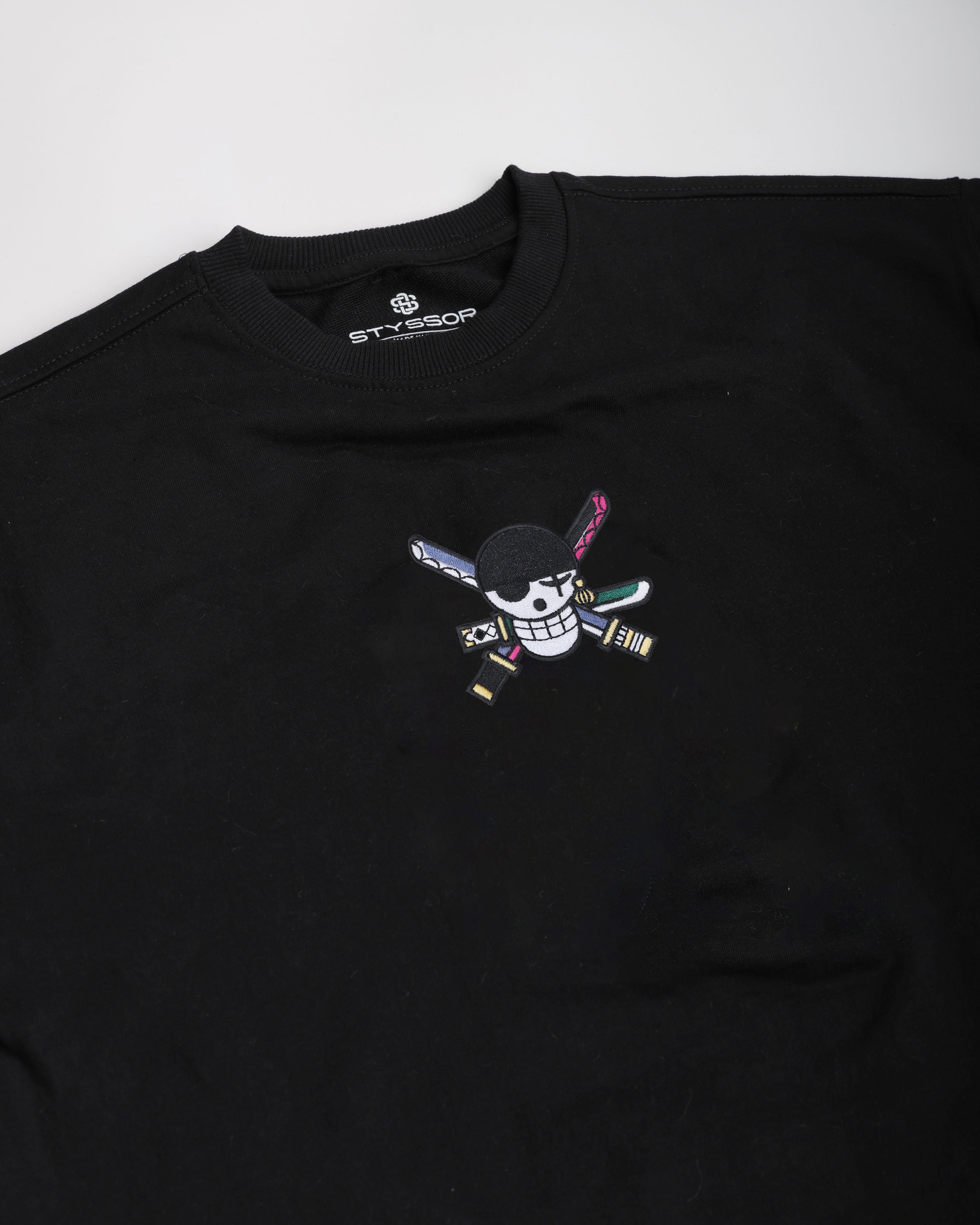 Black t-shirt with a colorful embroidered design on a white background
