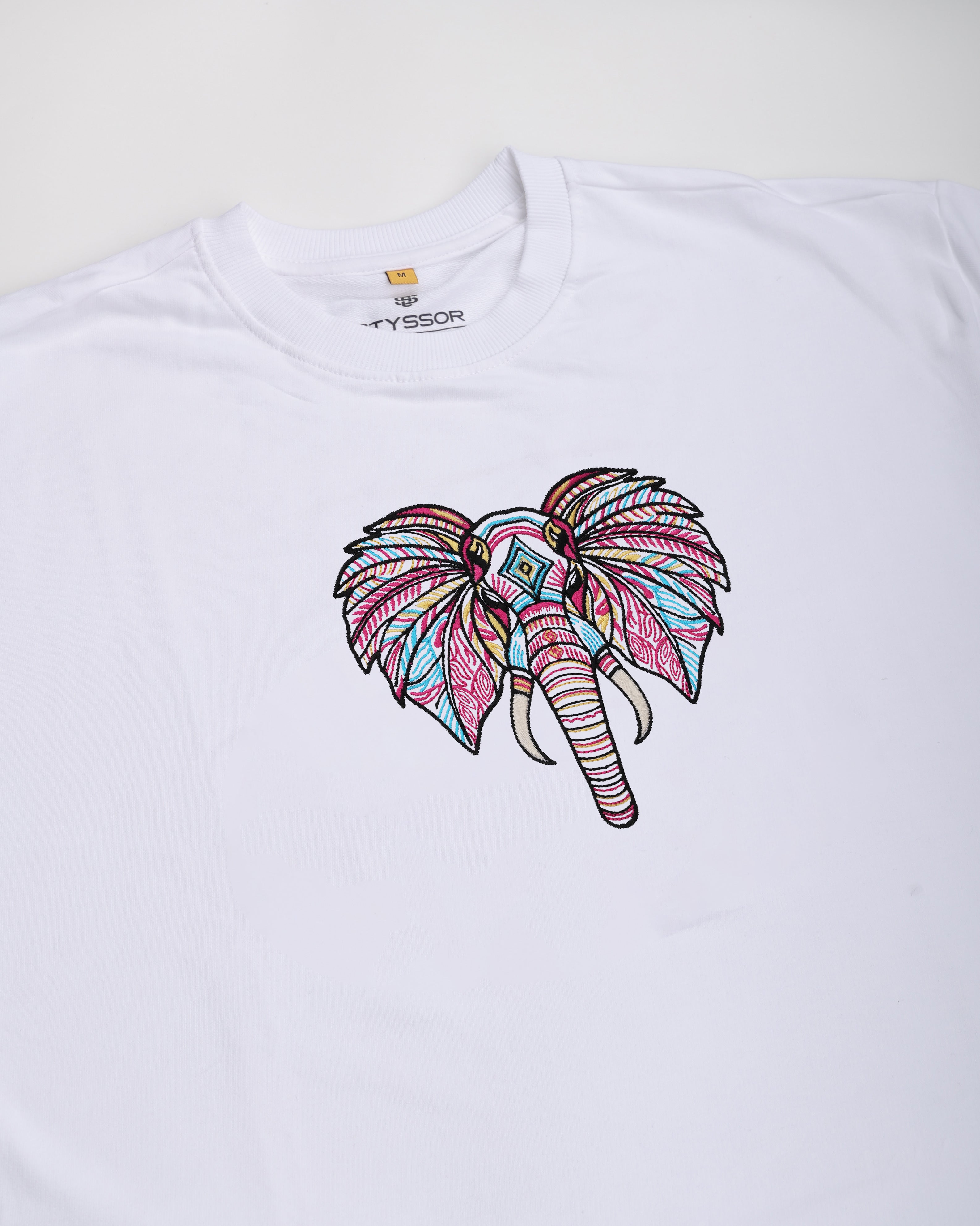 White t-shirt with a colorful elephant design on a white background