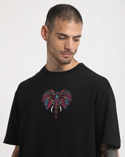 Man wearing a black t-shirt with a colorful elephant design on a white background