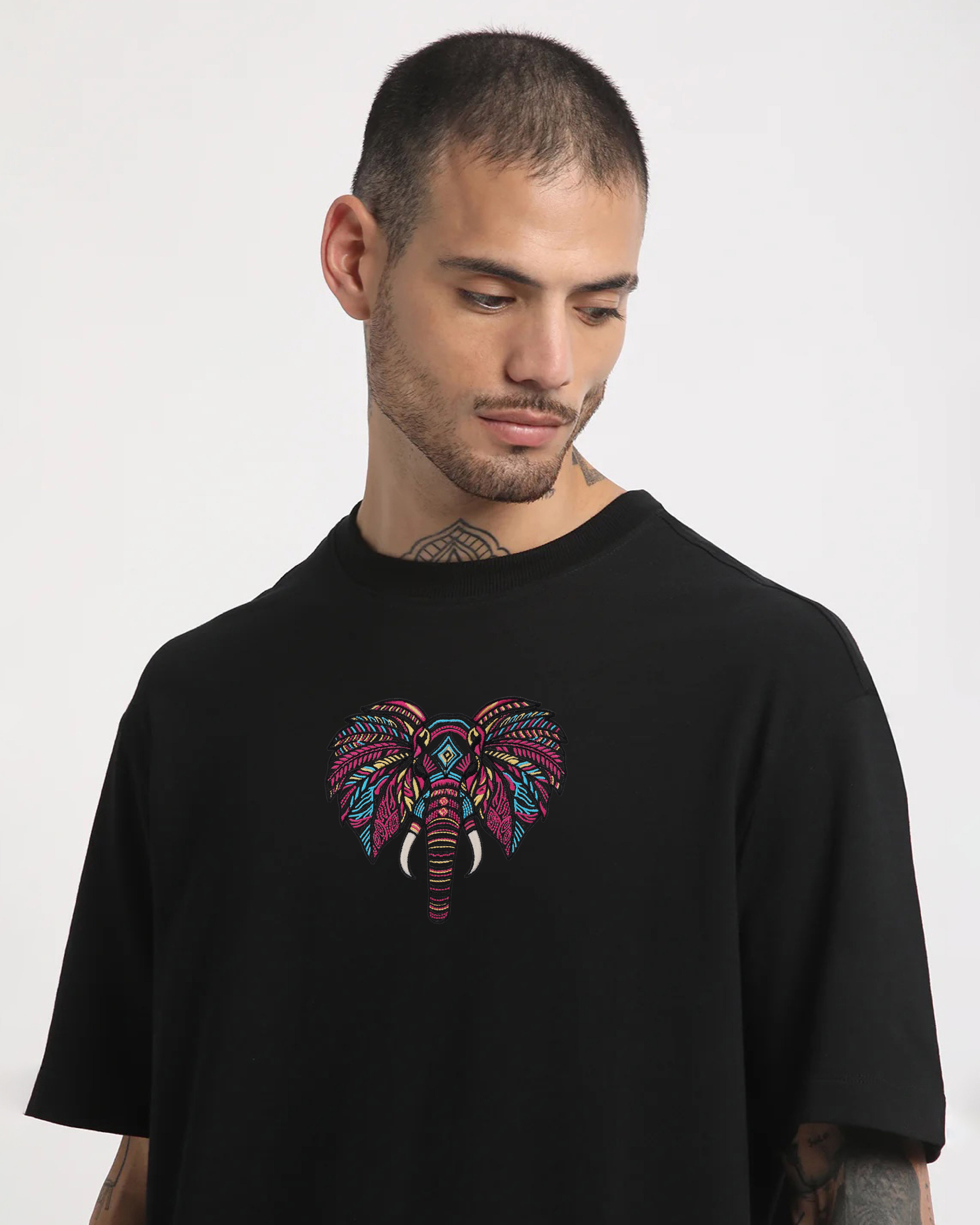 Man wearing a black t-shirt with a colorful elephant design on a white background