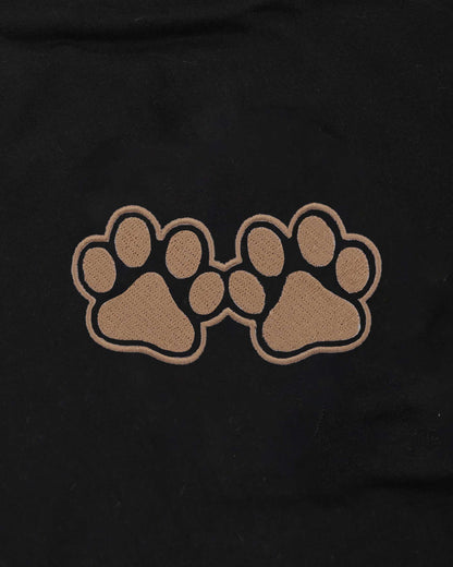 Two brown paw prints on a black background