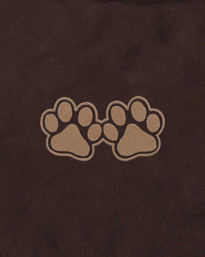 Two paw prints on a brown background