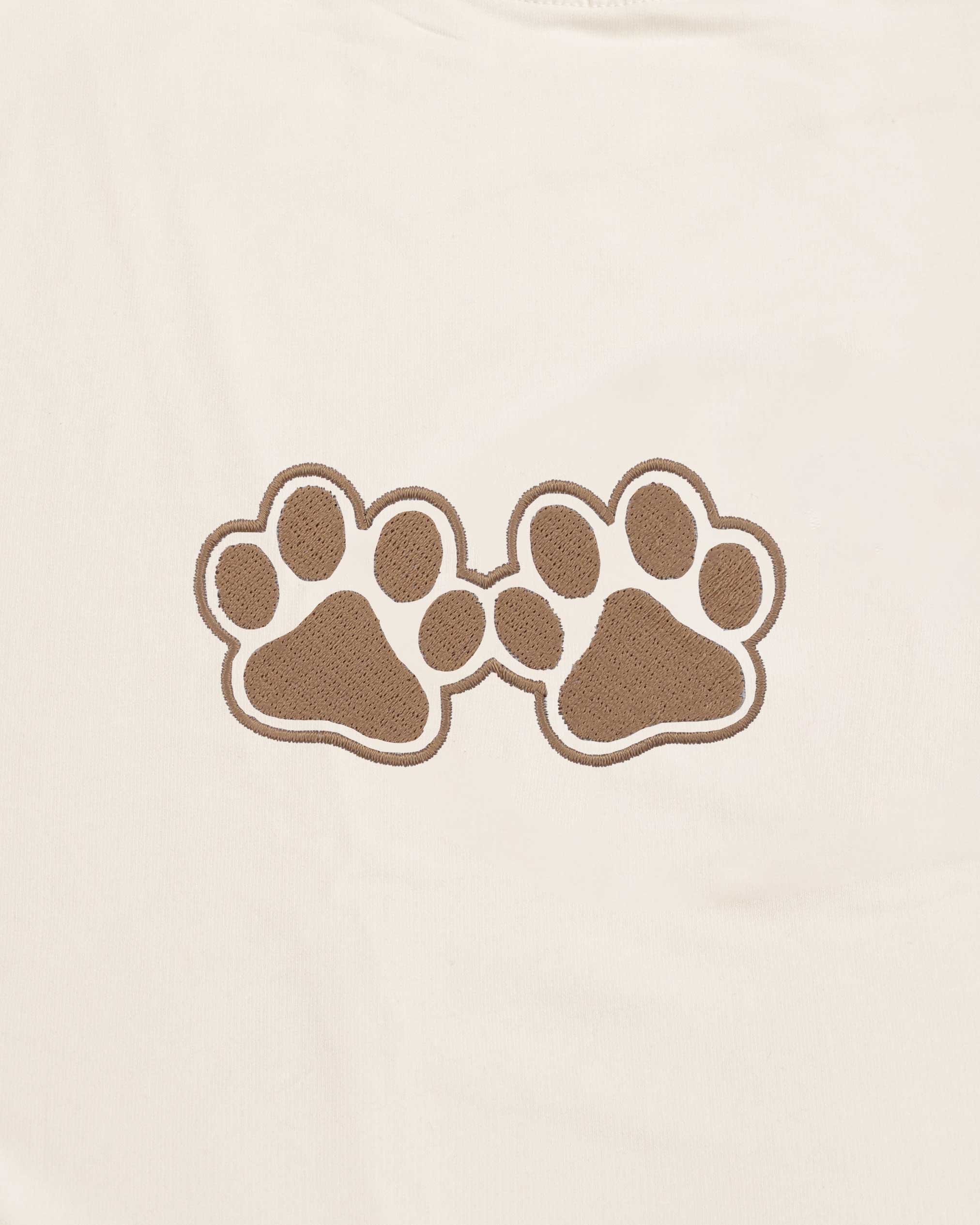 Two brown paw prints on a beige background