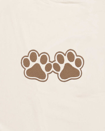 Two brown paw prints on a beige background