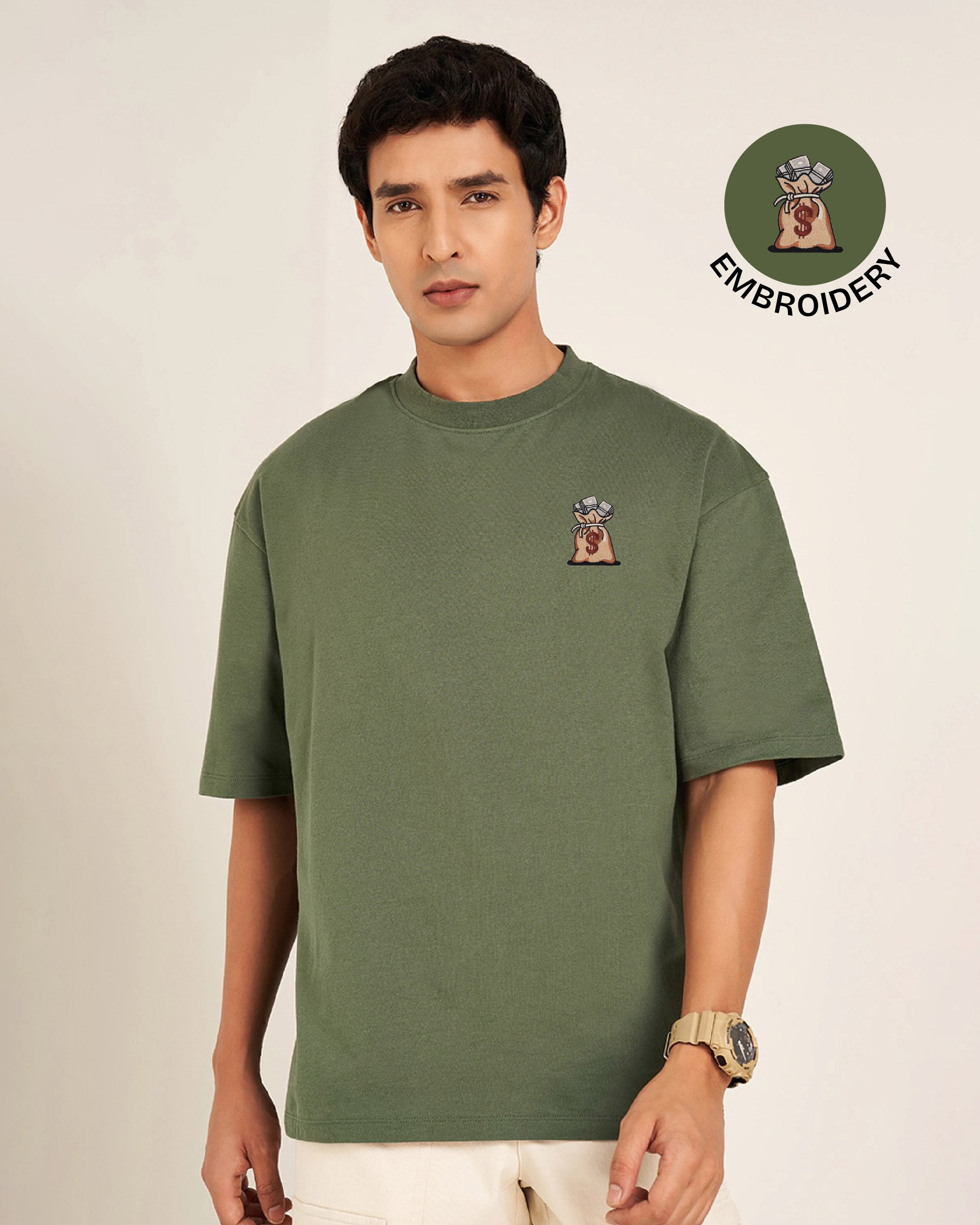 Man wearing a green t-shirt with embroidery on a beige background