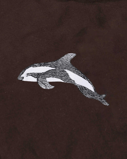 White whale embroidered on a brown fabric