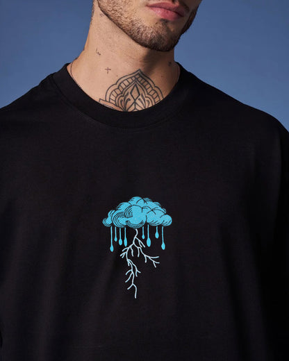 Person wearing a black sweatshirt with a blue cloud design on a blue background