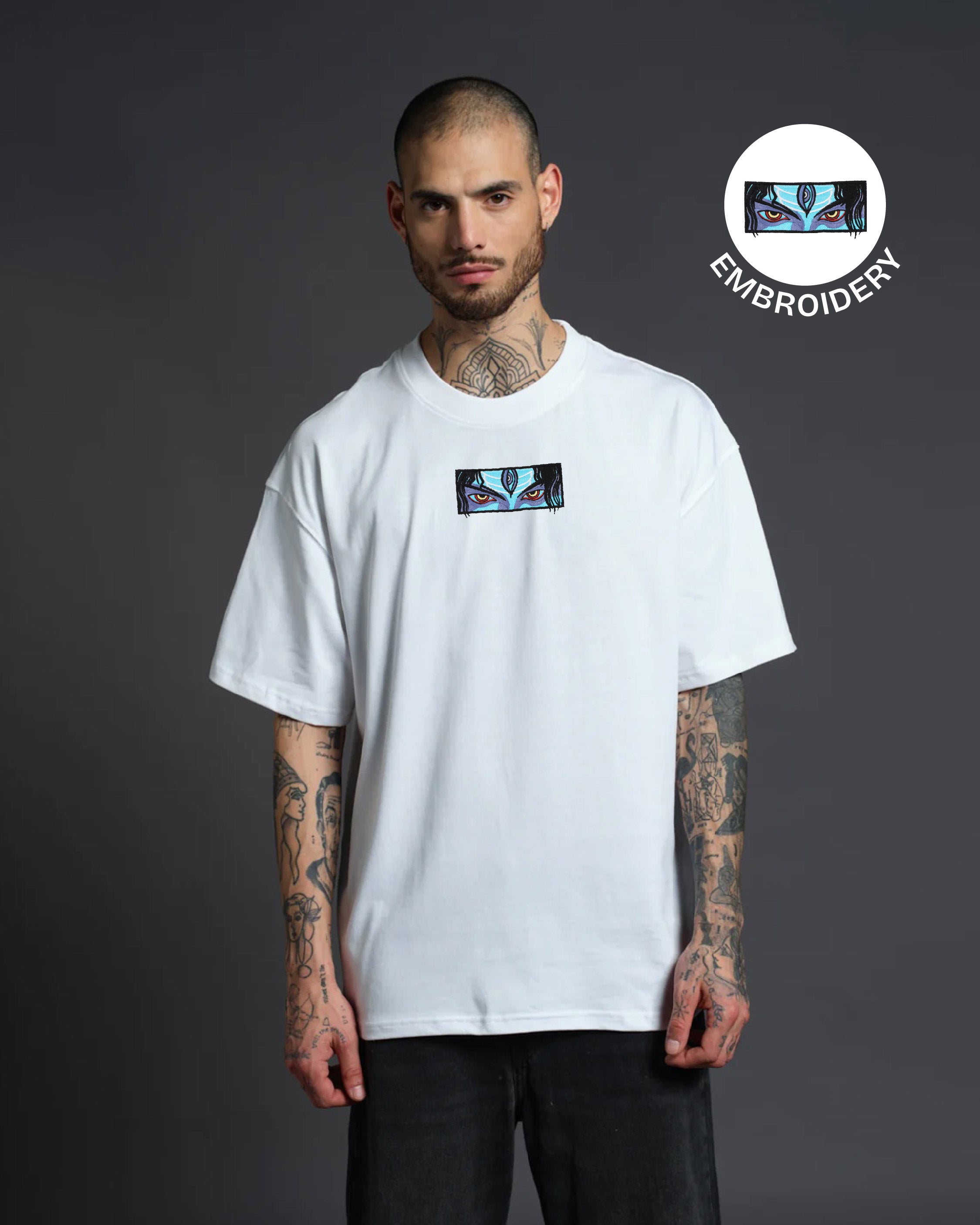 Man wearing a white t-shirt with a logo, standing against a dark background with embroidery logo overlay.