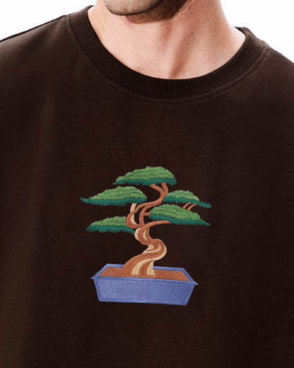 Brown sweatshirt with a embroidered bonsai tree design on a white background