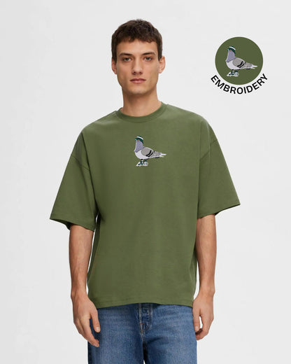 Man wearing a green t-shirt with a pigeon design on a white background