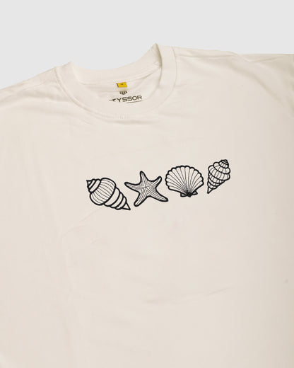Beige t-shirt with black shell and starfish designs on a white background