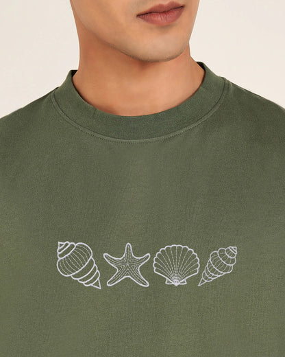 Green sweatshirt with white shell and starfish designs on a plain background