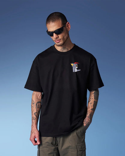 Man wearing a black t-shirt with a graphic design against a blue sky