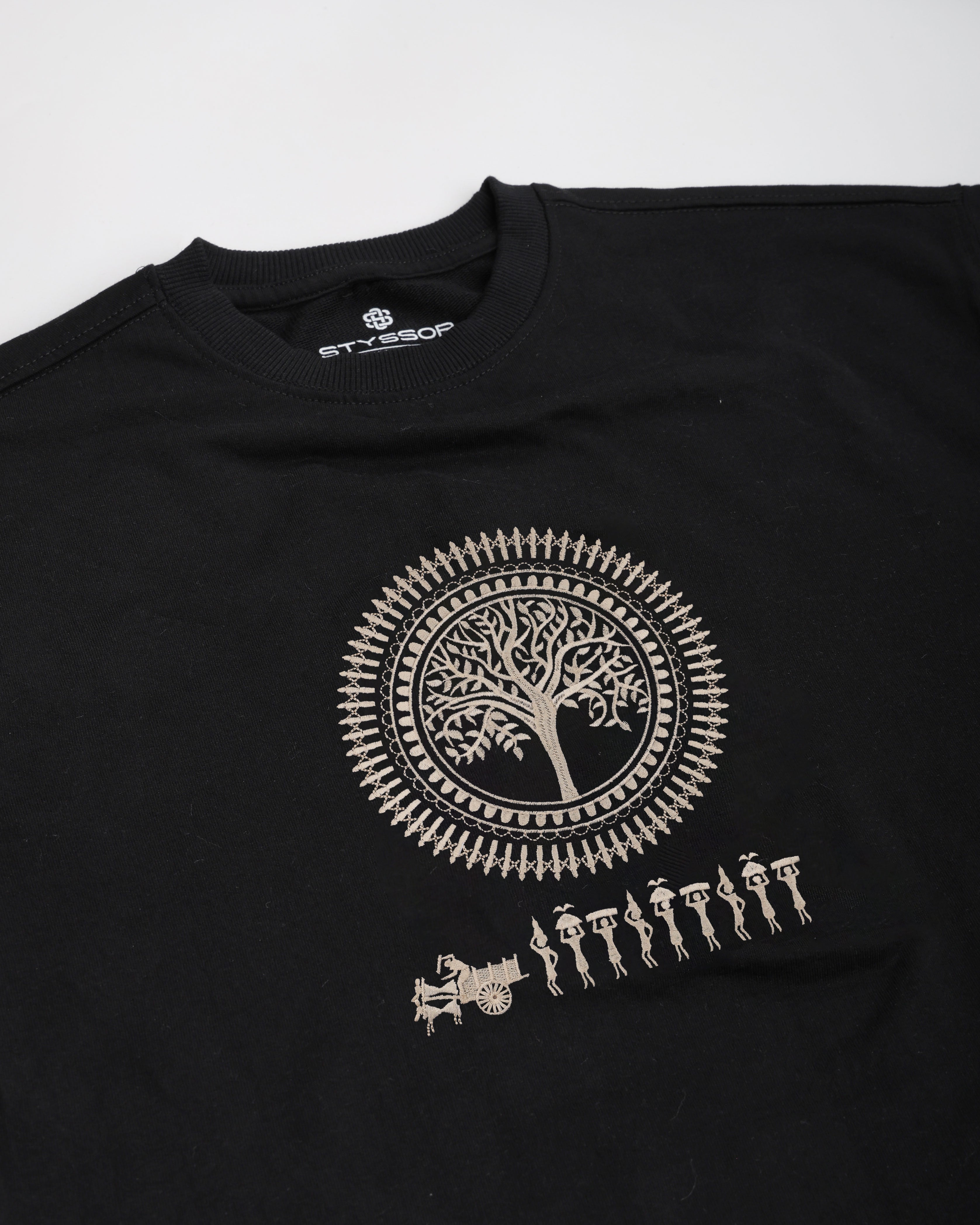 Black t-shirt with a white tree design and people figures on a white background