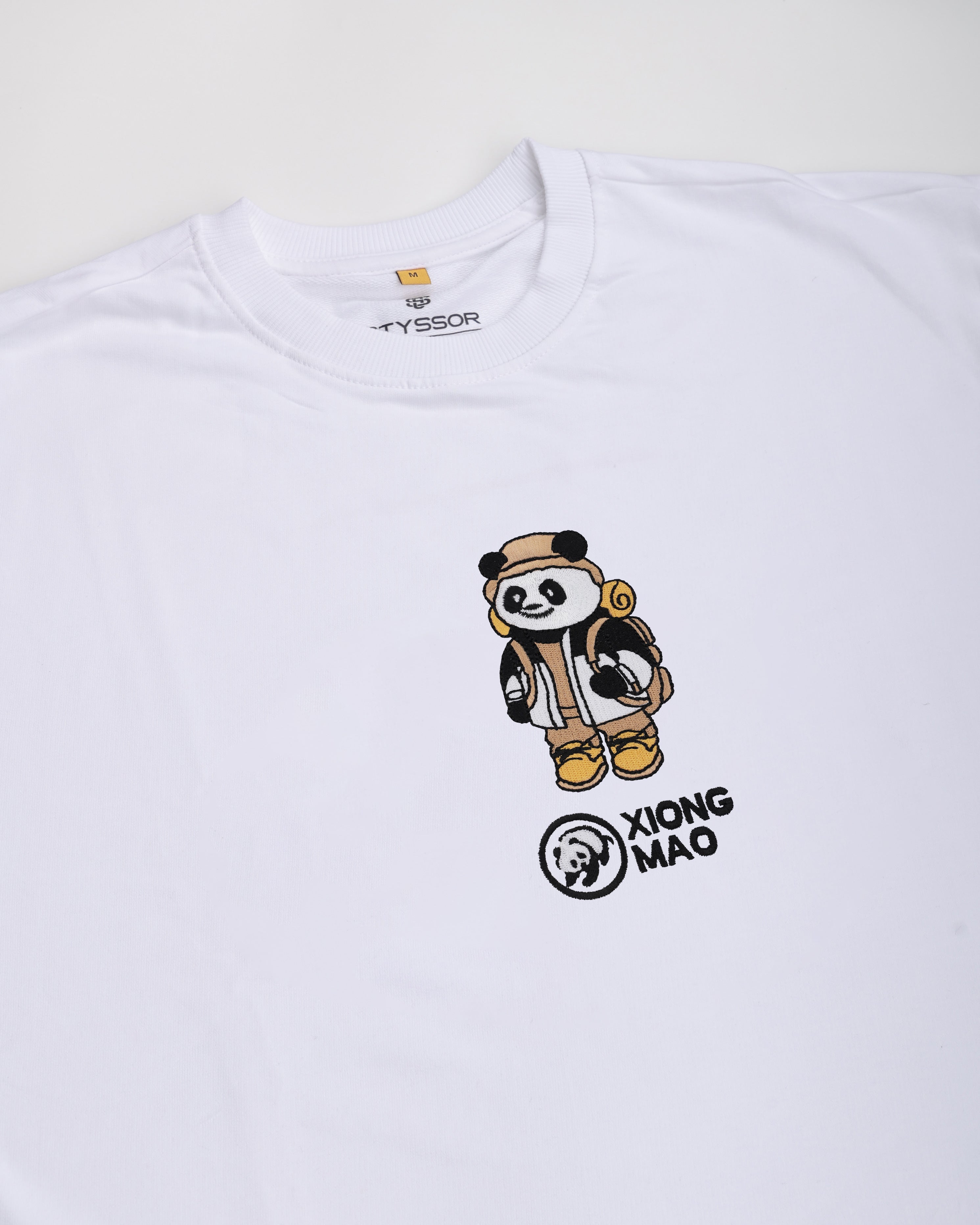 White t-shirt with a cartoon panda design and 'Xiong Mao' text on a white background