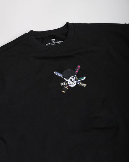 Black t-shirt with a colorful embroidered design on a white background