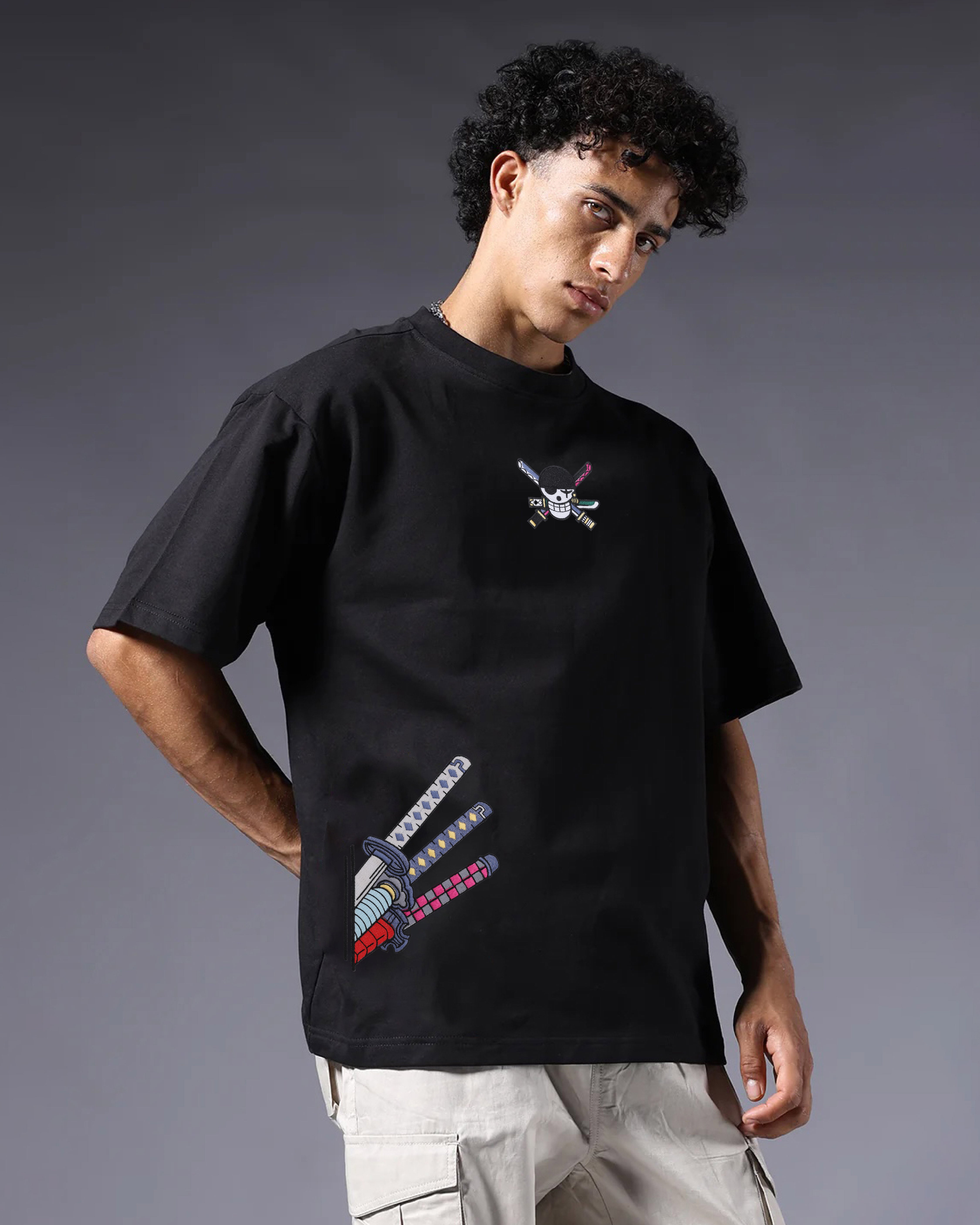 Person wearing a black t-shirt with graphic designs on a gray background